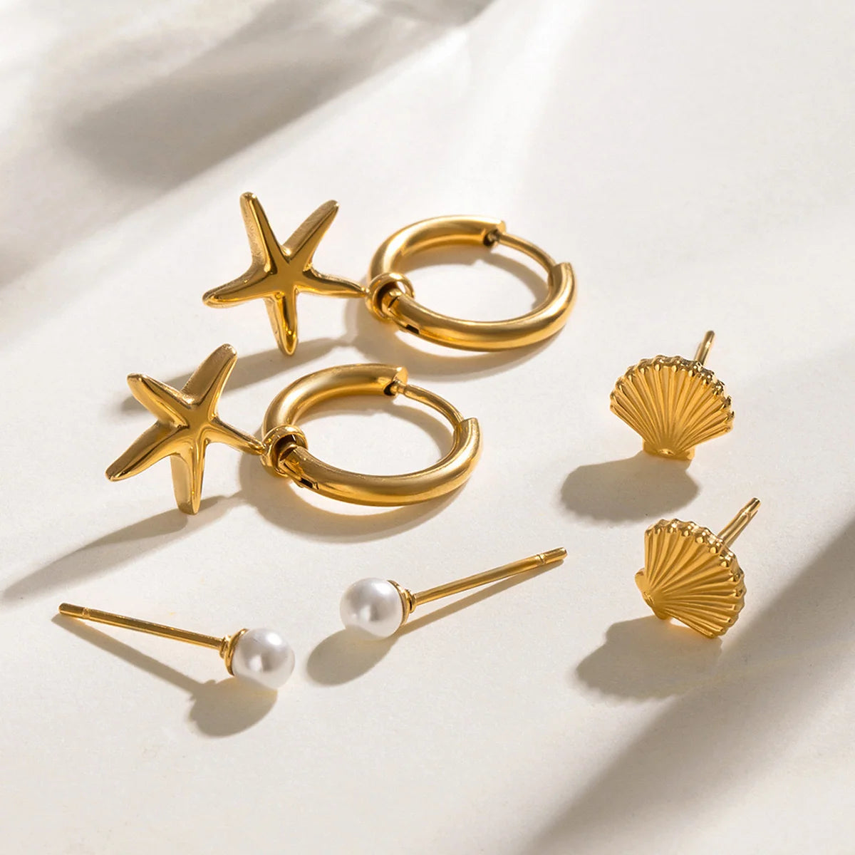 Melody gold earring set with starfish charm hoops, shell studs and pearl studs, view 3