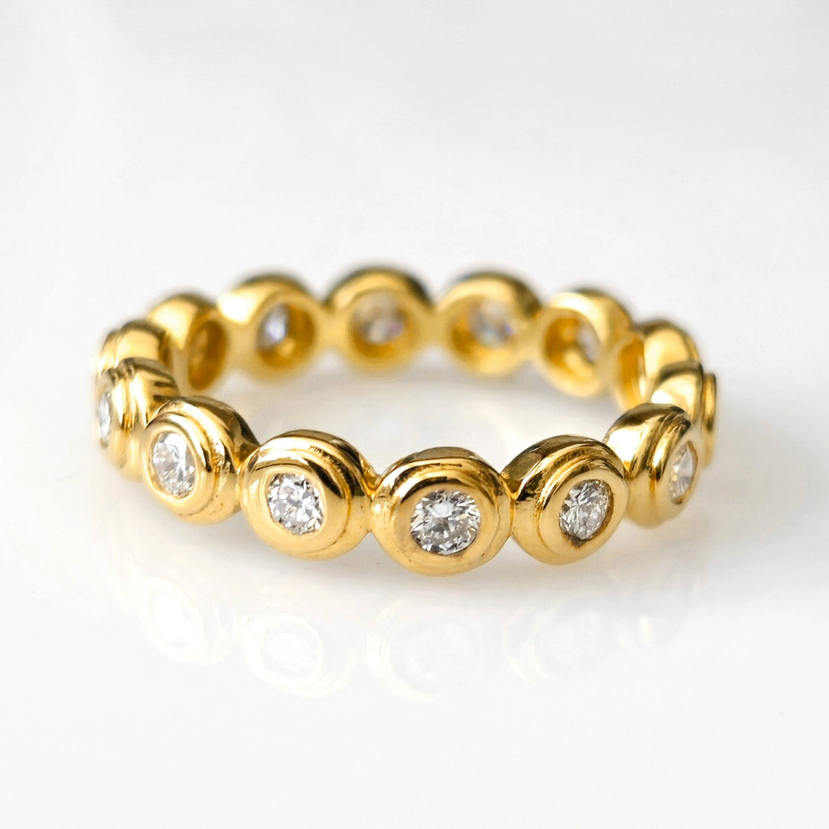 Lydia gold eternity band with bezel-set round stones