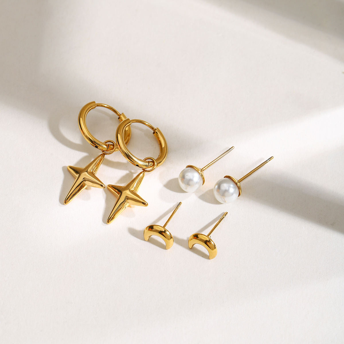 Maribel gold earring set with star charm hoops, pearl studs and moon studs, view 4