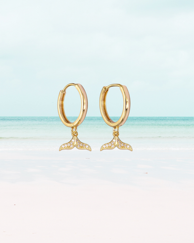 Saskia gold huggie earrings with pave crystal whale tail charm